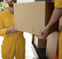 Movers handing boxes to eachother